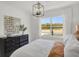 Bright bedroom with large window, stylish light fixture, and decorative wall mirror at 7384 Standish Ln, Avon, IN 46123