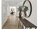 Long foyer hallway featuring wood floors, console table, mirror, and views into the dining room at 7384 Standish Ln, Avon, IN 46123