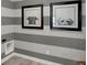 Hallway with gray and white horizontal stripes on the walls and two black-framed dog portraits at 7384 Standish Ln, Avon, IN 46123