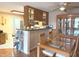 Dining space featuring hardwood floors and a glass table, adjacent to the kitchen at 7437 Vineyard Dr, Fishers, IN 46038