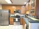 Efficient kitchen showcases stainless steel appliances, oak cabinets, and tile flooring at 7437 Vineyard Dr, Fishers, IN 46038