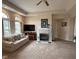 Cozy living room featuring a fireplace, a ceiling fan, and ample natural light through large windows at 7437 Vineyard Dr, Fishers, IN 46038