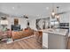 Open-concept living space with hardwood floors, a cozy fireplace, and a kitchen island with pendant lighting at 7450 Leatherwood Dr, Indianapolis, IN 46259