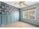 This charming bedroom features stylish wallpaper, wainscoting, a window, and a ceiling fan at 8333 Hunters Meadow Ct, Indianapolis, IN 46259