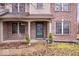 Inviting brick front porch with green door, flanked by small shrubs and neat landscaping at 8333 Hunters Meadow Ct, Indianapolis, IN 46259