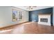 Bright living room featuring a cozy fireplace, hardwood floors, and a large window for natural light at 8333 Hunters Meadow Ct, Indianapolis, IN 46259