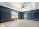 Spacious main bedroom featuring a tray ceiling, a ceiling fan, and a large window at 8333 Hunters Meadow Ct, Indianapolis, IN 46259