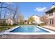 Backyard swimming pool with beautiful decking, surrounded by mature trees and landscaping at 8333 Hunters Meadow Ct, Indianapolis, IN 46259