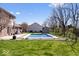 Outdoor pool surrounded by grassy lawn, mature trees, and adjacent to the home at 8333 Hunters Meadow Ct, Indianapolis, IN 46259