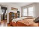 Bright bedroom featuring hardwood floors, a comfortable bed, and natural light from two windows at 837 Tecumseh St, Indianapolis, IN 46201