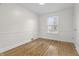 Cozy bedroom with hardwood floors, natural light from the window, and crisp white walls at 8615 El Rico Dr, Indianapolis, IN 46240