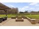 Backyard patio with cozy fire pit and scenic views of expansive green space with perimeter fencing and trees at 8810 E 200 S, Zionsville, IN 46077
