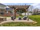 Backyard with pergola, patio and furniture set for entertaining, with a house and outbuilding in the background at 8810 E 200 S, Zionsville, IN 46077