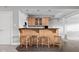 Basement bar area with pendant lighting, wooden cabinets, black countertops, and barstool seating at 8810 E 200 S, Zionsville, IN 46077
