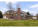 Rear exterior view of a beautiful brick home with a chimney and a well-maintained lawn at 8810 E 200 S, Zionsville, IN 46077