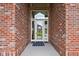Inviting front door with a glass panel and wreath, set in a classic red brick facade at 8810 E 200 S, Zionsville, IN 46077
