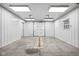 Bright and clean garage featuring white walls, concrete floors, a drain, and a roll-up door for convenient access at 8810 E 200 S, Zionsville, IN 46077