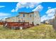 An exterior view of the house with a wooden deck, grassy yard and cloudy skies in the background at 10270 Yosemite Ln, Indianapolis, IN 46234