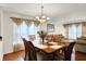 Dining room with chandelier, wood table, and sheer curtains at 10270 Yosemite Ln, Indianapolis, IN 46234