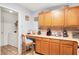 Cozy kitchen featuring wood cabinetry, a breakfast bar and access to the laundry room with modern appliances at 10270 Yosemite Ln, Indianapolis, IN 46234