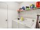 Functional laundry room equipped with a washer, dryer, storage shelves, and a white door at 10270 Yosemite Ln, Indianapolis, IN 46234