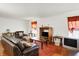 Open living room features wood floors, neutral walls, leather furniture, and large windows for natural light at 10270 Yosemite Ln, Indianapolis, IN 46234