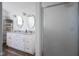 Bright bathroom with a shower and double vanity with granite counters and oval mirrors at 10920 Gate Cir, Fishers, IN 46038