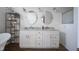 Bright bathroom featuring a double vanity with oval mirrors, granite counters, and a decorative plant shelf at 10920 Gate Cir, Fishers, IN 46038