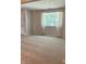 Inviting living room bathed in natural light from a large window and featuring neutral carpet at 1103 Charleston Commons Dr, Anderson, IN 46012