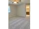 Carpeted main bedroom with a ceiling fan and a window, adjacent to the bathroom at 1103 Charleston Commons Dr, Anderson, IN 46012