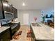 An open kitchen features dark cabinetry, stainless steel appliances, and a center island with sink at 11064 N Sashing Way, Monrovia, IN 46157