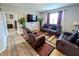 Comfortable living room featuring leather sofas, a large TV, hardwood floors, and plants for decor at 11064 N Sashing Way, Monrovia, IN 46157