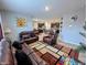 Open living room showcases leather sofas, a geometric rug, and seamless connection to the dining area and kitchen at 11064 N Sashing Way, Monrovia, IN 46157