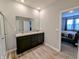 This is a shot of the main bath with a double vanity, modern cabinets, and an open door at 11064 N Sashing Way, Monrovia, IN 46157