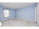 An empty room with light blue walls, neutral carpet, window and door leading to the rest of the house at 11363 Kristen Ln, Indianapolis, IN 46235