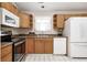 Well-equipped kitchen with stainless steel oven, white dishwasher, and wooden cabinets at 11363 Kristen Ln, Indianapolis, IN 46235