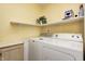 Well-lit laundry area with washer, dryer and shelving for storage and organizing laundry items at 11363 Kristen Ln, Indianapolis, IN 46235