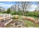 Secluded backyard featuring a wooden deck, mature trees, and a charming stone fire pit area at 13841 Waywing Ct, Carmel, IN 46033