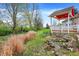 Landscaped backyard featuring a spacious deck with a charming pergola, mature trees, and stone accents at 13841 Waywing Ct, Carmel, IN 46033