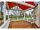 Covered deck with wood floors and white railings overlooking the picturesque backyard at 13841 Waywing Ct, Carmel, IN 46033