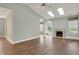 Open-concept living room with skylights, fireplace, hardwood floors, and access to a deck at 13841 Waywing Ct, Carmel, IN 46033