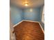 Cozy bedroom with wood floors, light blue walls, and a large window that brings in sunlight at 1425 W 9Th St, Anderson, IN 46016