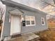 A closer view of a gray-sided home, showcasing the entrance and adjacent windows at 1425 W 9Th St, Anderson, IN 46016