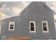 Side view of this charming one-story home showcasing three windows and gray siding at 1425 W 9Th St, Anderson, IN 46016