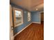 Inviting living room featuring wood floors, blue walls, and abundant natural light through the windows at 1425 W 9Th St, Anderson, IN 46016