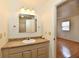 Well-lit bathroom featuring a vanity with countertop, mirror, and a view into an adjacent room at 1507 Park Dr, Lebanon, IN 46052