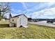 Exterior shot of a white storage shed with double doors, set in a grassy yard under a partly cloudy sky at 1507 Park Dr, Lebanon, IN 46052