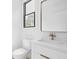 Charming powder room with white vanity, a gold faucet, and a framed mirror at 1526 Laurel St, Indianapolis, IN 46203