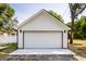 Exterior view of detached one car garage with white siding and a concrete driveway on a sunny day at 1526 Laurel St, Indianapolis, IN 46203