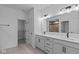 Bright bathroom featuring double vanity, white cabinets, and modern fixtures, complemented by a spacious walk-in closet at 16771 Cattle Hollow Ln, Noblesville, IN 46060